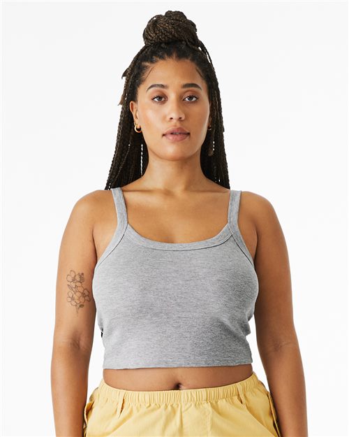 Load image into Gallery viewer, Against a white background, a person with long braided hair wears a gray BELLA + CANVAS Women's Micro Rib Spaghetti Strap Tank made from Airlume combed cotton, paired with yellow pants. The sustainably manufactured outfit includes fitted side seams and features a floral tattoo on their left arm.