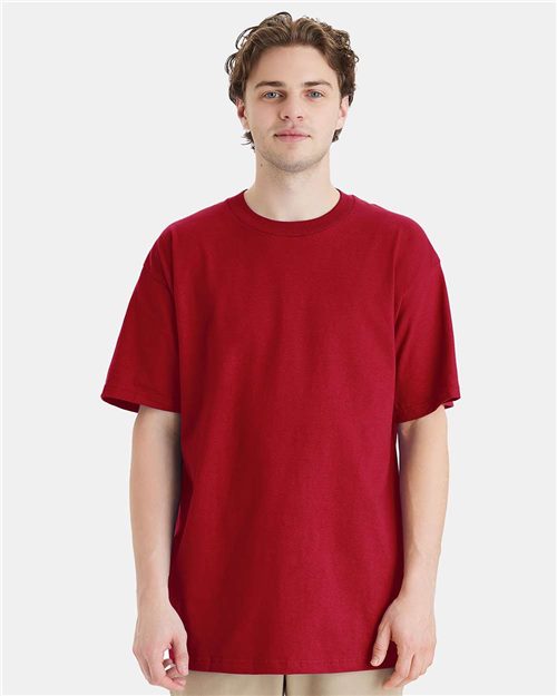 Load image into Gallery viewer, A person wearing a Hanes Beefy-T® Tall T-Shirt in red and beige pants stands against a white background, looking directly at the camera.