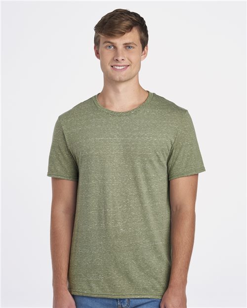 Load image into Gallery viewer, A person with short brown hair stands smiling against a plain white background, wearing a green JERZEES Snow Heather Jersey T-Shirt and blue jeans, projecting a responsible mindset.