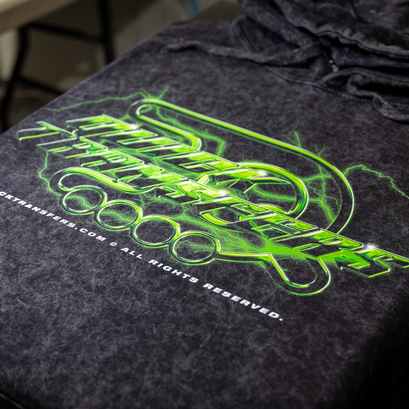 Load image into Gallery viewer, Close-up of a black t-shirt with a neon green graphic "ONOCK TRANSFERS" in stylized text. Partially visible are a URL and "All Rights Reserved." The fabric's light mottling enhances the FASTFILM™ quality DTF printing by Quick Transfers for this design.