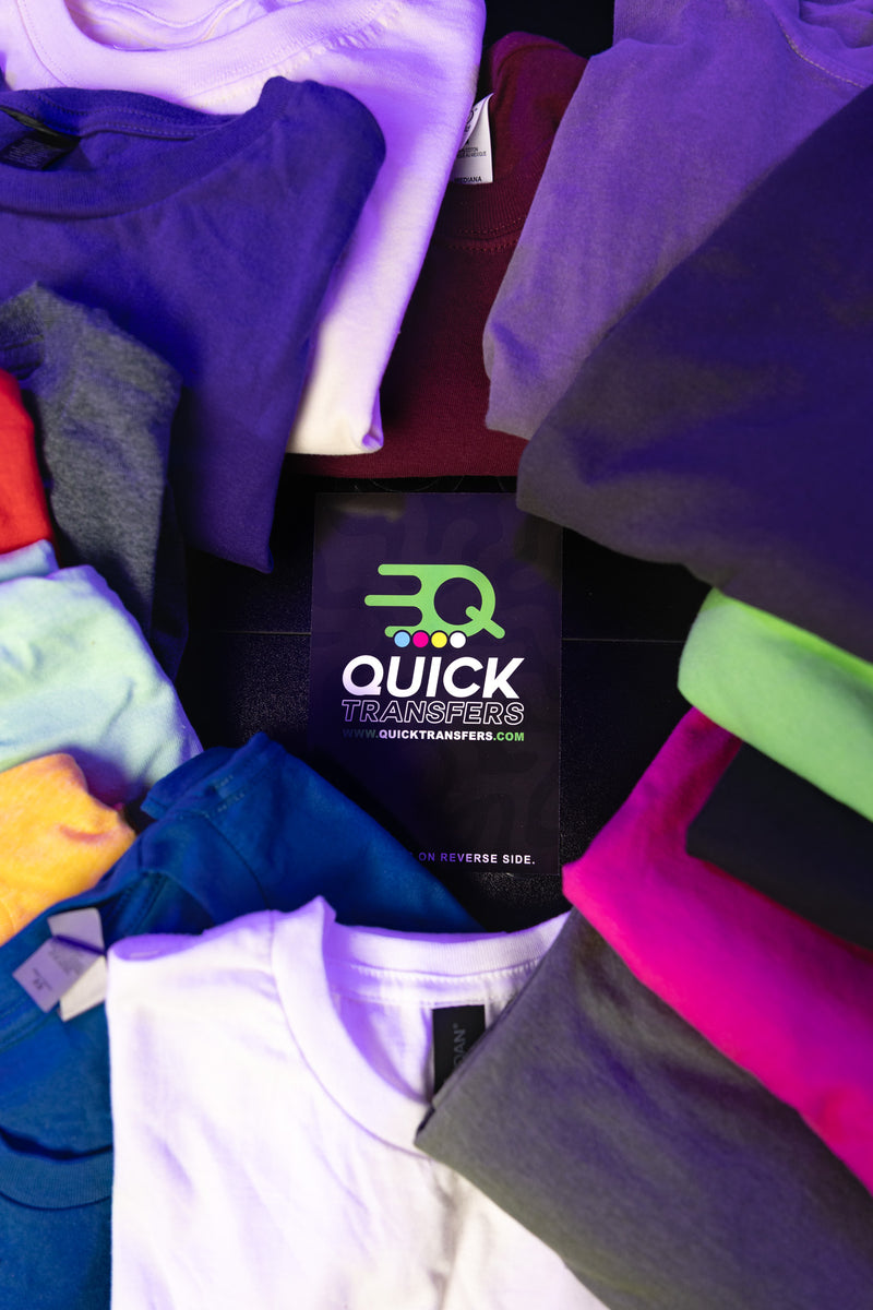 Load image into Gallery viewer, A circle of colorful folded shirts surrounds a card with the Quick Transfers logo and website, perfectly showcasing our Short Sleeve Shirt Mystery Bundle.