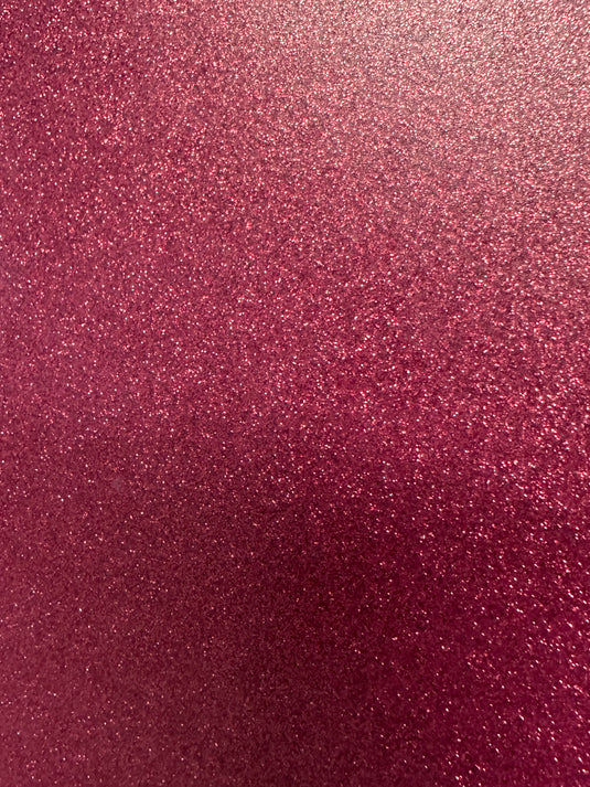 The image showcases Quick Transfers' EconoGlitter Vinyl, 19.8" x 12", featuring a durable, sparkling pink glitter texture that fills the space with a shimmering visual effect. The varied particle sizes reflect light, adding depth to its vibrant pink surface.