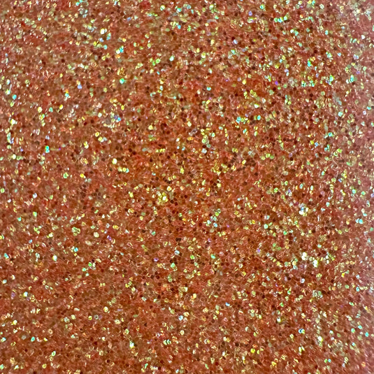 Close-up of copper EconoGlitter Vinyl by Quick Transfers scattered densely, reflecting light for a sparkling effect with pink and gold hints. The textured surface appears vibrant, showcasing the durable Glitter Heat Transfer Vinyl's lively and dynamic visual.