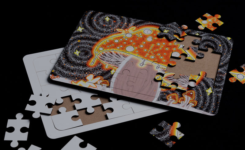 Load image into Gallery viewer, A partially completed puzzle of a colorful, stylized mushroom and swirling background rests on a cardboard frame. Loose pieces scattered over the dark surface echo designs crafted through sublimation printing by Quick Transfers' "Sublimation Transfers - Transfers By Size" collection.