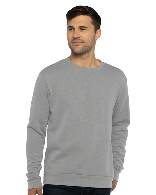 A man with short dark hair wears a Next Level - Malibu Crewneck Sweatshirt, designed by Next Level for a relaxed fit and socially conscious manufacturing, standing against a white background and facing slightly to the right.