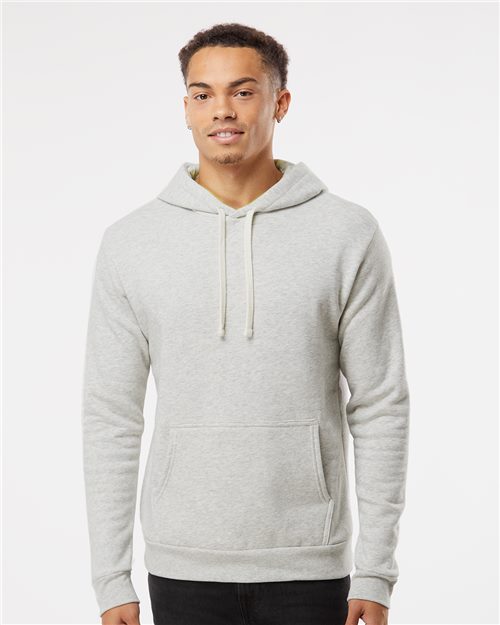 Load image into Gallery viewer, Against a white backdrop, someone in a Next Level - Malibu Hoodie by Next Level, made of light gray cotton/polyester fleece with a front pocket, sports short hair and a slight smile. They embody the essence of socially conscious manufacturing.
