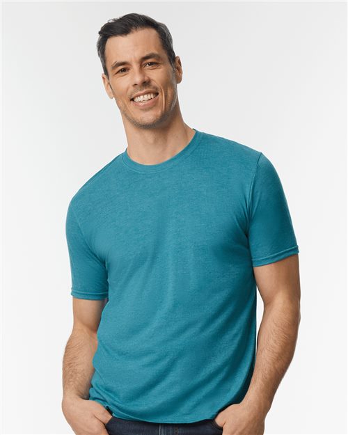 Load image into Gallery viewer, A man smiles in a Gildan Softstyle® Triblend T-Shirt and dark jeans, set against a plain white background.
