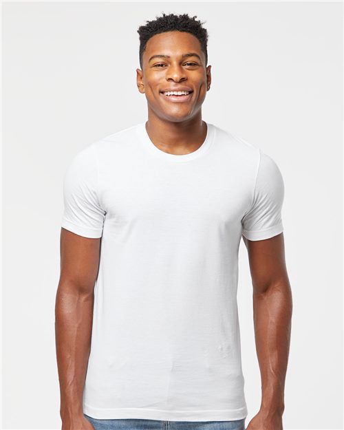 A man is smiling and standing against a plain white background, wearing a Tultex Premium Cotton T-Shirt in white and blue jeans.