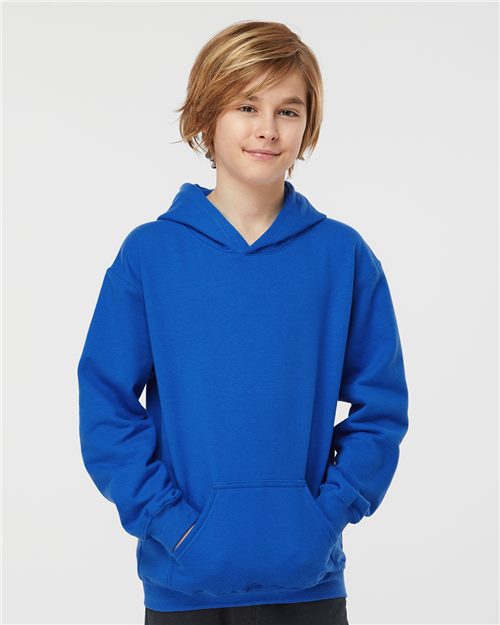 Load image into Gallery viewer, A young individual with medium-length hair wears a Tultex Youth Hooded Sweatshirt, showcasing its bright blue ring-spun cotton fabric and cozy front pocket against a plain white background, highlighting the hoodie’s comfort and quality.
