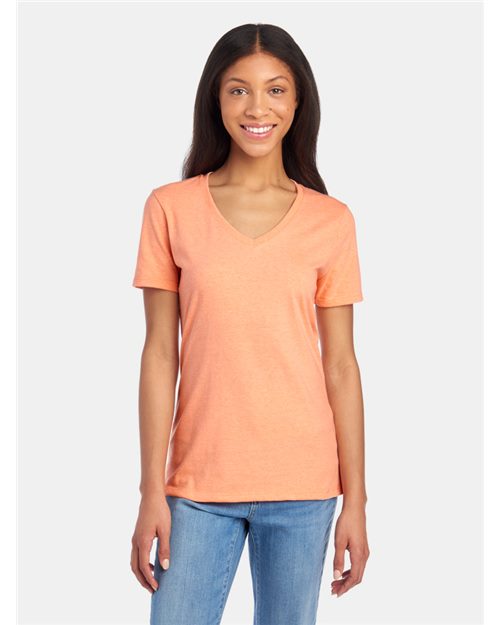 Load image into Gallery viewer, With long hair and a smile, a person stands against a white background wearing an orange JERZEES Women&#39;s Premium Blend V-Neck T-shirt made from USA-grown cotton and blue jeans.
