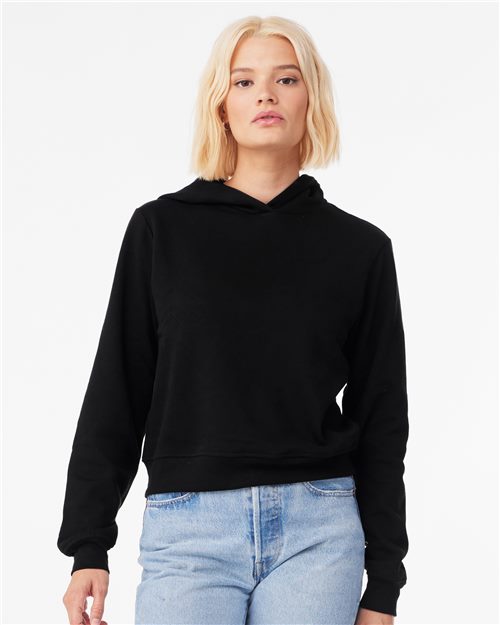 Load image into Gallery viewer, A person with shoulder-length blonde hair wears the BELLA + CANVAS Women&#39;s Classic Hoodie in black and light blue jeans. They stand against a plain white background, showcasing sustainable manufacturing principles in stylish simplicity.
