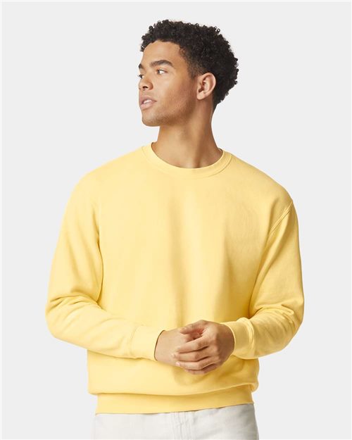 Load image into Gallery viewer, Wearing a Comfort Colors Garment-Dyed Lightweight Fleece Crewneck Sweatshirt in yellow and light-colored pants, a person looks to the side against a plain background.
