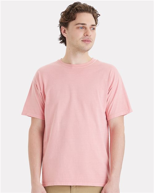 Load image into Gallery viewer, Person wearing a ComfortWash by Hanes Botanical Dyed T-Shirt in pink and beige pants, standing against a plain background.
