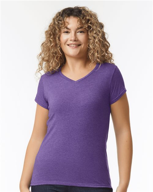 Load image into Gallery viewer, A person with curly hair is smiling and wearing a Gildan - Softstyle® Women’s V-Neck T-Shirt in purple, made of soft ring-spun cotton, against a plain white background.
