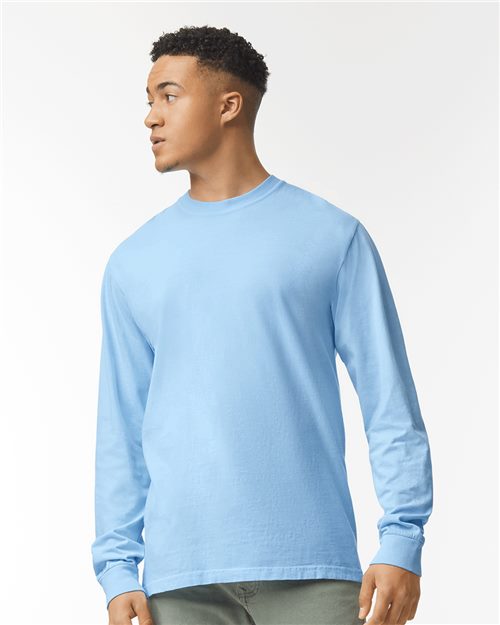 Load image into Gallery viewer, A person wears a Comfort Colors Garment-Dyed Heavyweight Long Sleeve T-Shirt in light blue with green pants, showcasing sustainable style. The OEKO-TEX certified outfit pops against the plain white background as they look to the side.
