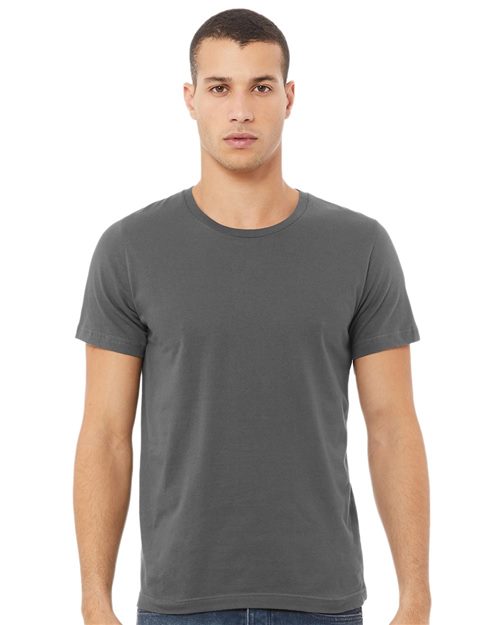 A person stands facing forward wearing a plain gray BELLA + CANVAS - USA-Made Jersey Tee, made from sustainable Airlume combed and ring-spun cotton. The unisex fit complements their short dark hair and neutral expression against a white background.