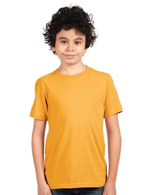 A young person with curly hair, wearing a Next Level - Youth Cotton T-Shirt in plain orange and made by Next Level using socially conscious manufacturing, stands against a white background, looking directly at the camera with a neutral expression.