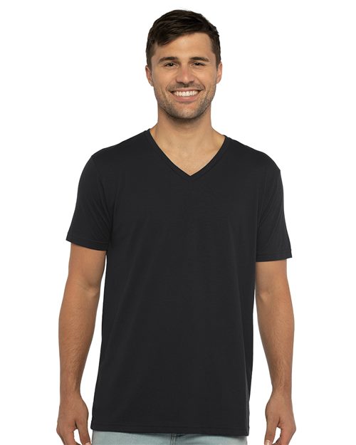 Load image into Gallery viewer, A man smiles while wearing the Next Level - Sueded V-Neck T-Shirt in black and light blue jeans, standing against a white background. The unisex fit of the outfit reflects a commitment to sustainable style.
