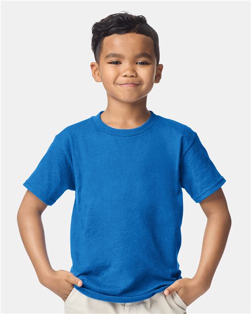 Load image into Gallery viewer, A young boy with short dark hair confidently smiles, hands on his hips. He wears a Gildan DryBlend® Youth T-Shirt in blue and beige pants, standing against a plain white background, embodying the essence of sustainable manufacturing.
