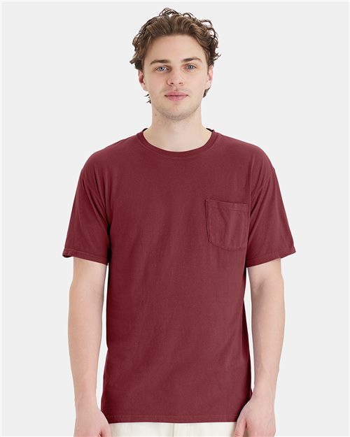 Load image into Gallery viewer, A person in a ComfortWash by Hanes Garment-Dyed Pocket T-Shirt, against a white background. The maroon shirt, made of ring-spun cotton, enhances their short, wavy hair, blending comfort and style.
