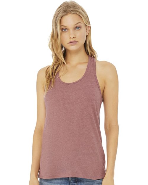 Load image into Gallery viewer, A person with long blonde hair in a sleeveless mauve BELLA + CANVAS Women&#39;s Jersey Racerback Tank, crafted from Airlume combed and ring-spun cotton, and blue jeans stands against a plain white background. Their arms are relaxed by their sides, subtly showcasing sustainable manufacturing.
