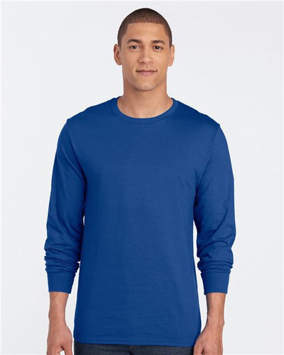 A person wears the JERZEES Premium Blended Ringspun Long Sleeve Crewneck T-Shirt in plain blue, made with socially conscious practices, standing against a white background, facing forward.