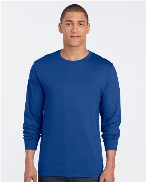 Load image into Gallery viewer, A person wears the JERZEES Premium Blended Ringspun Long Sleeve Crewneck T-Shirt in plain blue, made with socially conscious practices, standing against a white background, facing forward.
