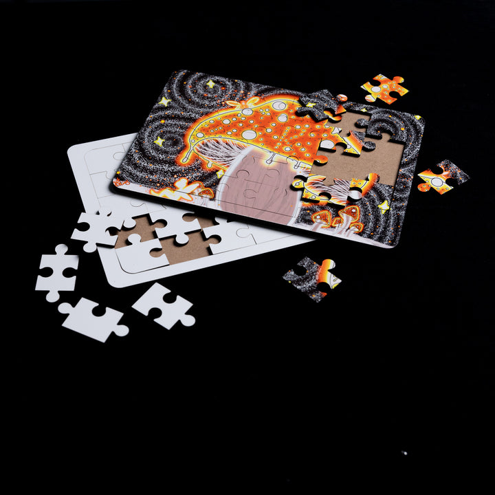 The Blank Sublimation Puzzle (5x7") by Quick Transfers showcases a colorful mushroom and swirling patterns on a black background. Puzzle pieces, scattered around the image, add a personal touch as they await their perfect fit.