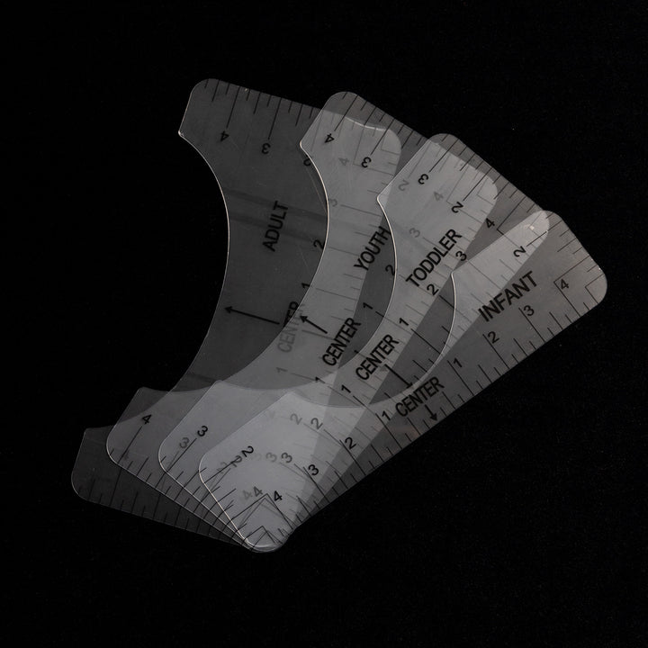 The Quick Transfers Alignment Ruler set delivers professional quality for apparel decoration. These transparent curved rulers are labeled for adults, youth, toddlers, and infants. Arranged in a fan shape on a dark background, each ruler has inch markings and a "CENTER" label.