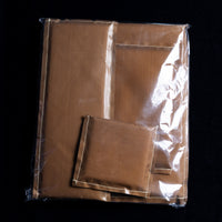 The Press Pillows (4 Pack) by Quick Transfers include neatly folded brown Teflon fabric sheets and matching pouches, all heat-resistant and packaged in clear plastic against a black backdrop.