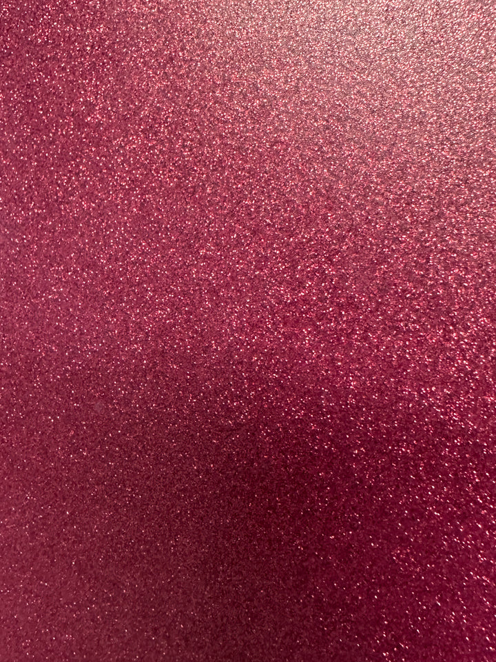 The image showcases Quick Transfers' EconoGlitter Vinyl, 19.8" x 12", featuring a durable, sparkling pink glitter texture that fills the space with a shimmering visual effect. The varied particle sizes reflect light, adding depth to its vibrant pink surface.