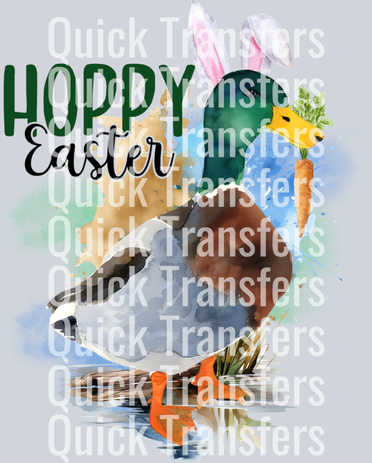 The Vibrant Hoppy Easter Mallard With Bunny Ears Transfer by Quick Transfers features a mallard duck with bunny ears holding a carrot by water, “Hoppy Easter” text at the top left, and “Quick Transfers” watermarked throughout the design.